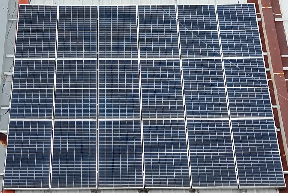 Visible-light aerial photo of the same 18-module rooftop array; the affected module looks normal