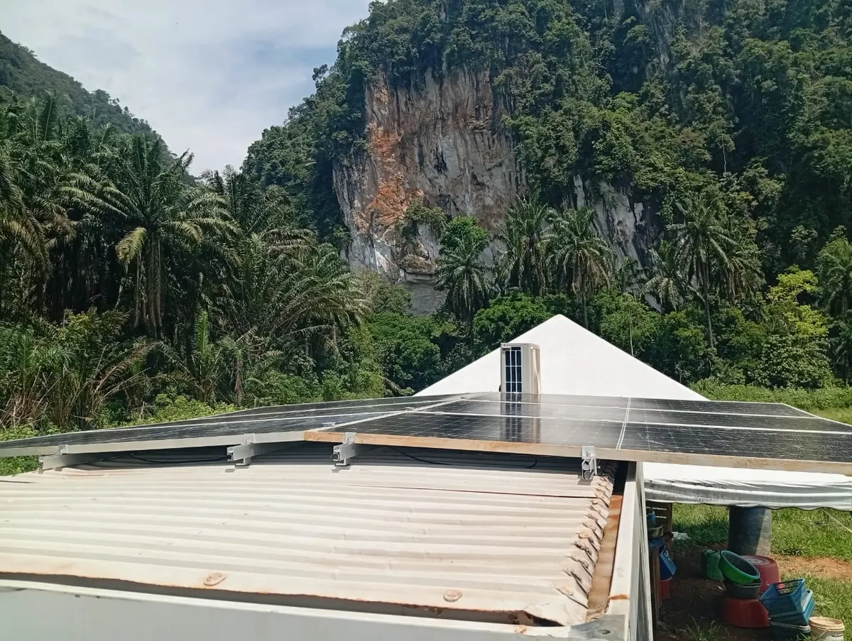 Solar panels on a cabin roof below limestone hills