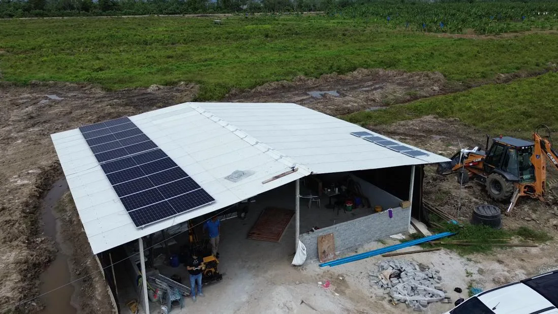 Aerial view of solar panels on the roof of an open farm shed